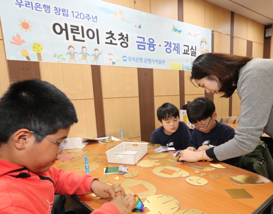 우리금융은 지난달 30일 서울시 중구에 소재한 우리은행 박물관에서 유치원생, 초등학생들을 대상으로 ‘어린이 금융·경제교실’을 개최했다. 어린이들이 황금돼지 저금통을 직접 만들고 있다. 우리금융그룹 제공